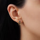 A side-profile view of a model wearing a 14k yellow gold Anna earring, showing the scale of the tiered blue sapphire setting and how the delicate mariner link chains loop and dangle gently below the earlobe.