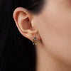 A side-profile view of a model wearing a 14k yellow gold Anna earring, showing the scale of the tiered blue sapphire setting and how the delicate mariner link chains loop and dangle gently below the earlobe.